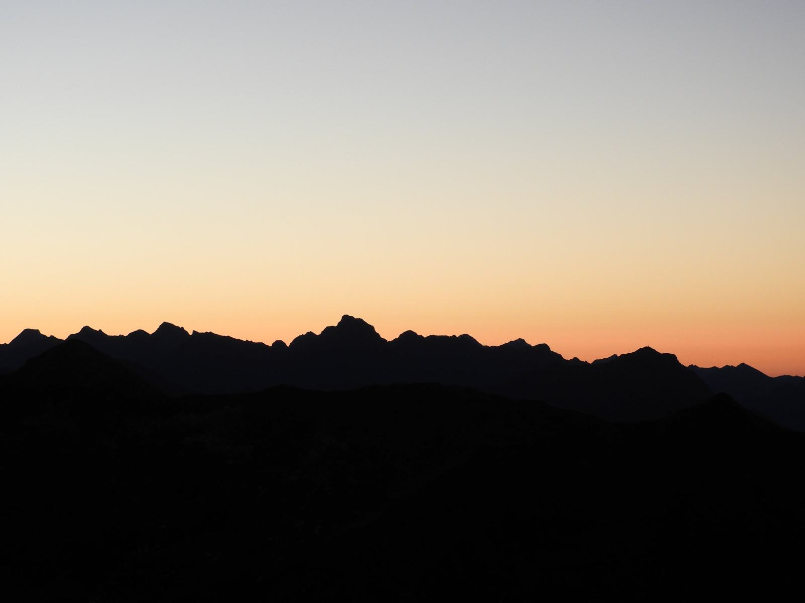 Silhouet van een bergkam in de Aostavallei bij zonsondergang