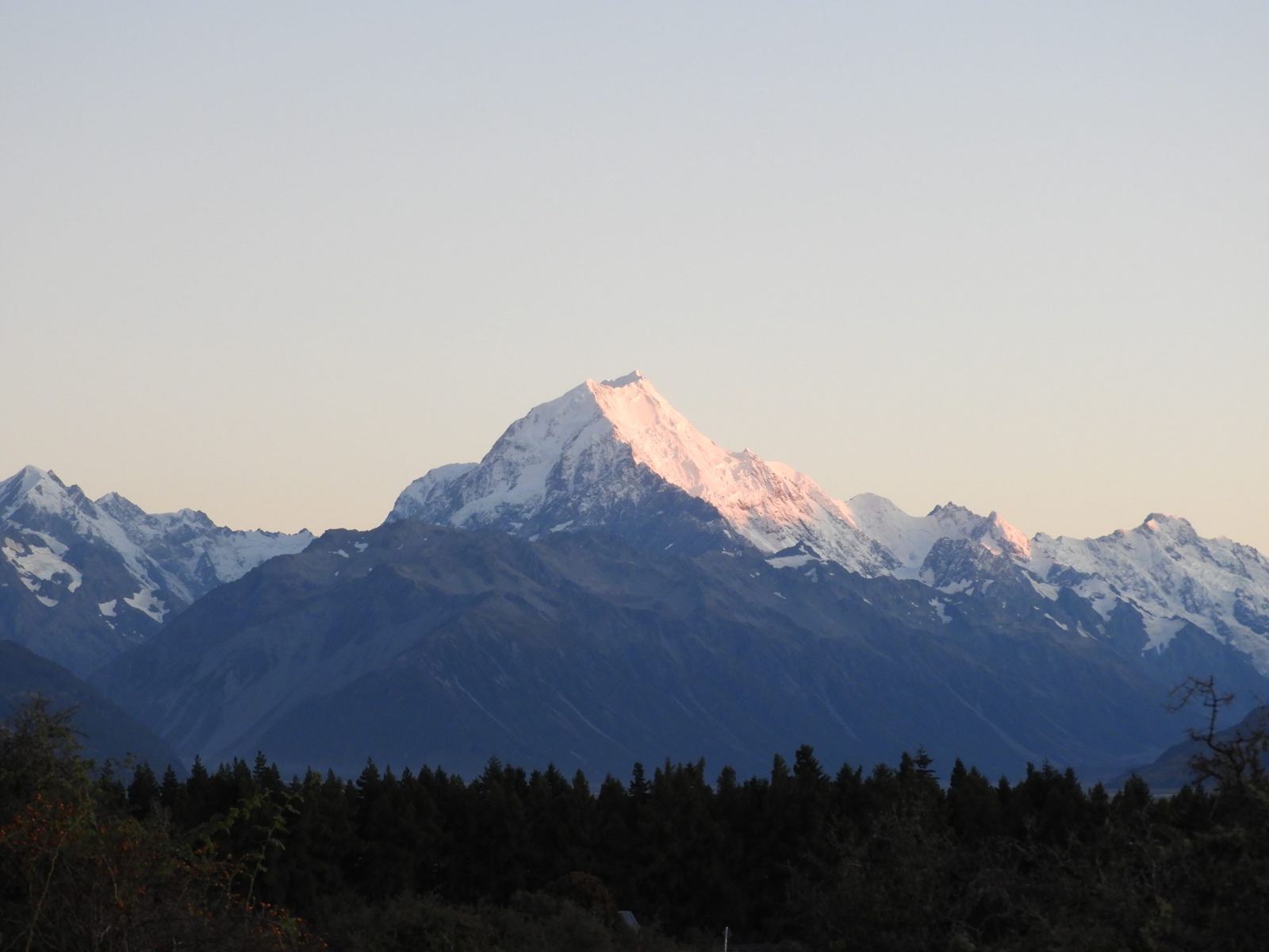Besneeuwde bergtop in avondlicht